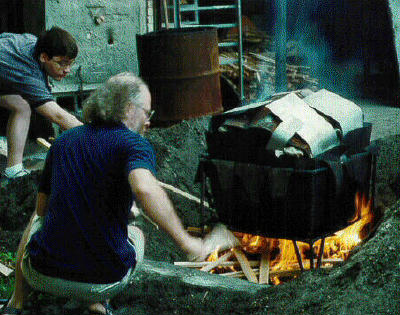 (Carl & Don put wood on fire)